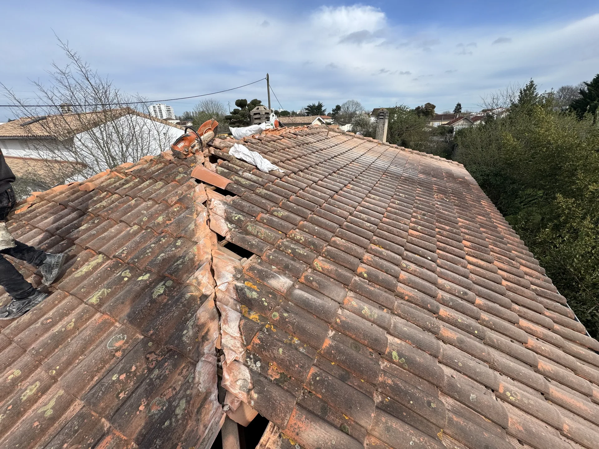 Artisan couvreur posant des tuiles neuves sur la charpente d'une maison