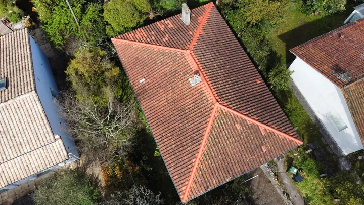 Vue du dessus d’un toit à plusieurs pans avec lignes de faîtage et cheminée